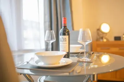 a bottle of wine sitting on a table with two glasses at Beautiful Ground Floor Victorian Apartment in Clacton-on-Sea