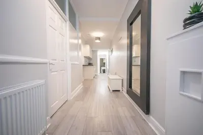 an empty hallway with white walls and a wooden floor at Beautiful Ground Floor Victorian Apartment in Clacton-on-Sea