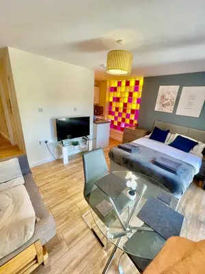 a living room with a bed and a glass table at cambridge city centre immaculate Studio sleeps 2 - central location paradise street in Cambridge