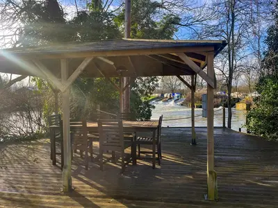 a wooden gazebo with a table and chairs on a deck at Island Lodge - Uk46767 in Little Baddow