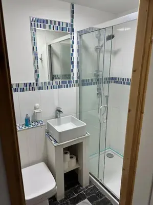 a bathroom with a glass shower and a sink at The Hideout in Linton