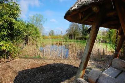 a view of a pond with a bench in front at 2 Bed in Attleborough oc-1277 in Old Buckenham