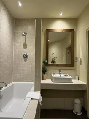 a bathroom with a tub and a sink and a mirror at Mulberry Tree in Attleborough