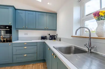 a kitchen with blue cabinets and a sink at 1 Bed in Tasburgh oc-t28242 in Ashwellthorpe