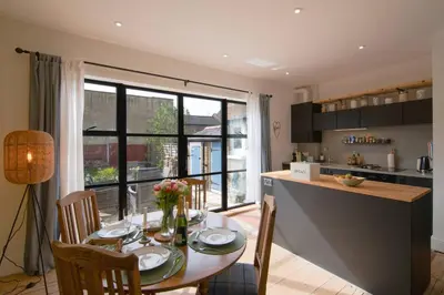 a kitchen and dining room with a table with chairs at Cosy Stylish house near Southend - Pass the Keys in Southend-on-Sea