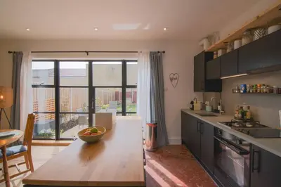 a kitchen with a table with a bowl of fruit on it at Cosy Stylish house near Southend - Pass the Keys in Southend-on-Sea