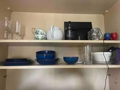 a shelf with bowls and other dishes on it at Entire studio with private parking and balcony in Southend-on-Sea