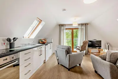 a kitchen with white cabinets and a living room at 2 Bed in Eccles oc-l27507 in Eccles