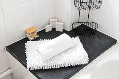 a black counter with white towels on it in a bathroom at Beautiful House by Station with Private Parking in Cambridge