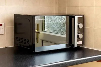 a microwave sitting on top of a counter at Beautiful House by Station with Private Parking in Cambridge