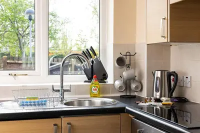 a kitchen counter with a sink and a window at Beautiful House by Station with Private Parking in Cambridge
