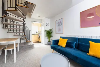 a living room with a blue couch and a table at Beautiful House by Station with Private Parking in Cambridge