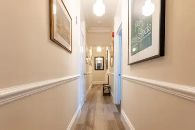 a hallway with white walls and wood floors and framed pictures at 1 Bed in Aldeburgh oc-h28976 in Aldeburgh