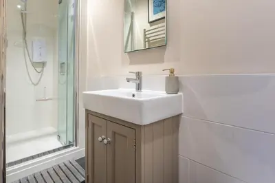 a bathroom with a white sink and a shower at 1 Bed in Aldeburgh oc-h28976 in Aldeburgh