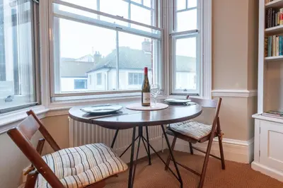 a table with a bottle of wine in a room with windows at 1 Bed in Aldeburgh oc-h28976 in Aldeburgh
