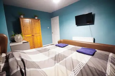 a bedroom with a bed and a tv on the wall at 3 Bedroom home by Ipswich docks. in Ipswich