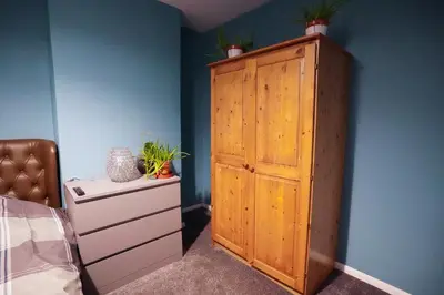 a bedroom with a wooden cabinet with potted plants on it at 3 Bedroom home by Ipswich docks. in Ipswich