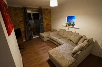 a living room with a couch and a table at 3 Bedroom home by Ipswich docks. in Ipswich