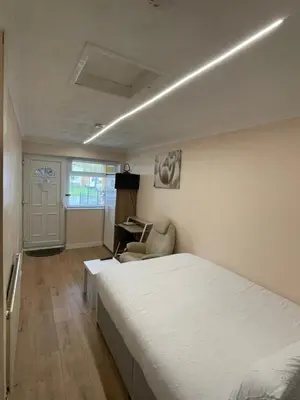 a bedroom with a bed and a desk in it at Welcoming Guesthouse in Cambridge