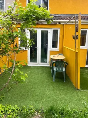 a patio with a table and a chair in front of a building at Welcoming Guesthouse in Cambridge