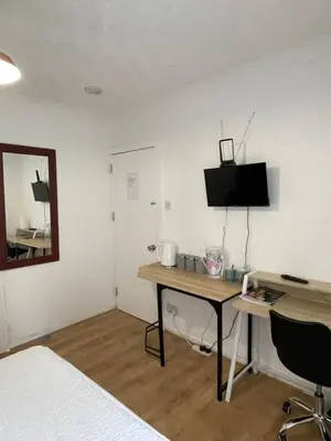 a bedroom with a desk and a bed and a mirror at Welcoming Guesthouse in Cambridge