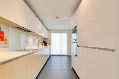 a kitchen with white walls and a long hallway at Pass the Keys 53 Austin Drive · Modern Townhouse near Addenbrookes Own Parking in Cambridge