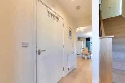 a hallway with a white door and a staircase at Pass the Keys 53 Austin Drive · Modern Townhouse near Addenbrookes Own Parking in Cambridge