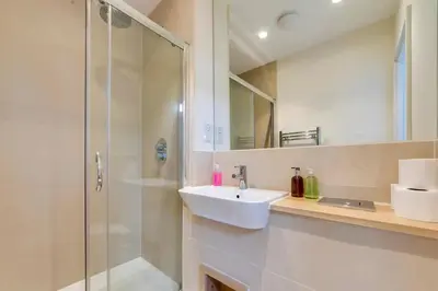 a bathroom with a glass shower and a sink at Pass the Keys 53 Austin Drive · Modern Townhouse near Addenbrookes Own Parking in Cambridge