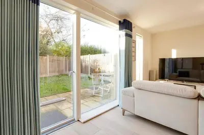 a living room with a sliding glass door to a patio at Pass the Keys 53 Austin Drive · Modern Townhouse near Addenbrookes Own Parking in Cambridge