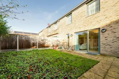 a backyard of a brick building with a fence at Pass the Keys 53 Austin Drive · Modern Townhouse near Addenbrookes Own Parking in Cambridge