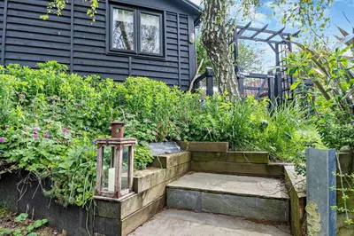 a garden with a lantern and a house at 1 Bed in Chelmondiston oc-l29137 in Chelmondiston