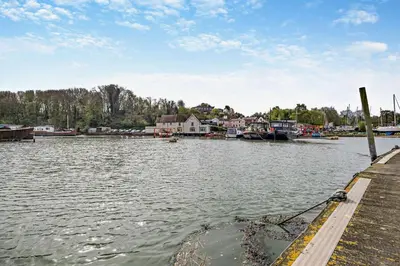 a body of water with a dock with boats in it at 1 Bed in Chelmondiston oc-l29137 in Chelmondiston