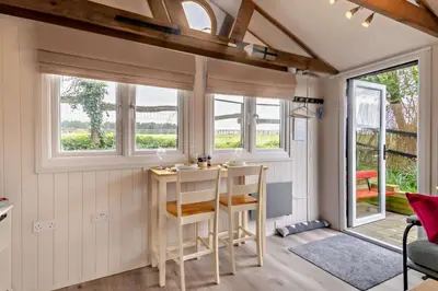 a small kitchen with a table and chairs in a tiny house at 1 Bed in Chelmondiston oc-l29137 in Chelmondiston