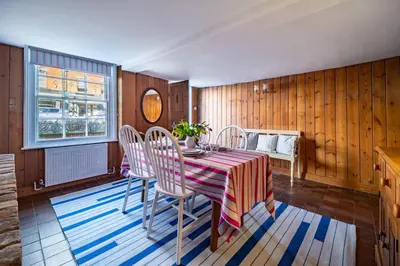 a dining room with a table and chairs and a window at Marine Cottage in Aldeburgh