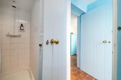 a bathroom with a tub and a toilet and a shower at Marine Cottage in Aldeburgh