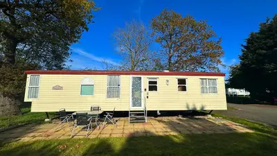 a yellow rv with chairs and a table and chairs at Getaway House in Clacton-on-Sea