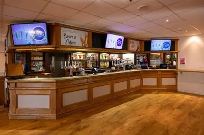a bar with several televisions on the wall at Getaway House in Clacton-on-Sea