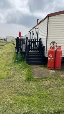 two red fire hydrants sitting next to a building at Caravan home Clacton-On-Sea St Osyth in Saint Osyth