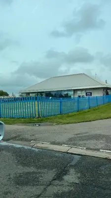 a blue fence in front of a building at Caravan home Clacton-On-Sea St Osyth in Saint Osyth