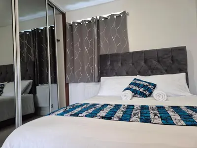a bedroom with a large bed with a large mirror at Double Room in a shared 4 bedroom family home in Broomfield in Chelmsford