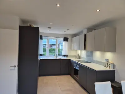 a kitchen with black and white cabinets and a window at Double Room in a shared 4 bedroom family home in Broomfield in Chelmsford