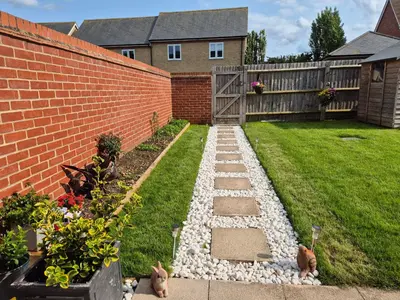 a garden with a brick wall and some plants at Double Room in a shared 4 bedroom family home in Broomfield in Chelmsford