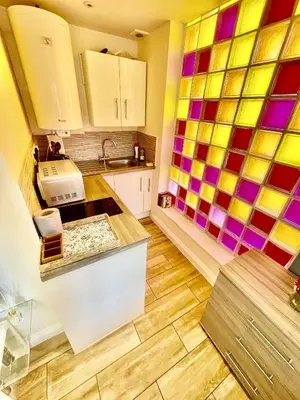 a kitchen with colorful tiles on the wall at 1 Bed Studio - Sleeps 2 - Parking - Wifi in Cambridge