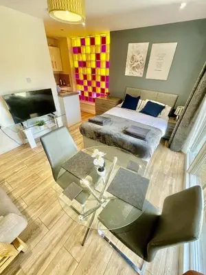 a bedroom with a bed and a table and a tv at 1 Bed Studio - Sleeps 2 - Parking - Wifi in Cambridge