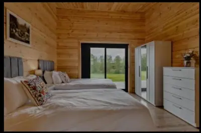 a large bedroom with two beds and a dresser at Meadow Valley Lodge 4 in Ipswich