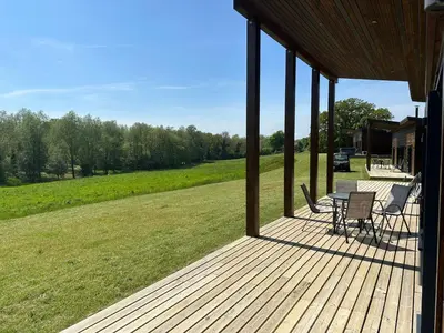 a porch of a house with a table and chairs at Meadow Valley Lodge 4 in Ipswich