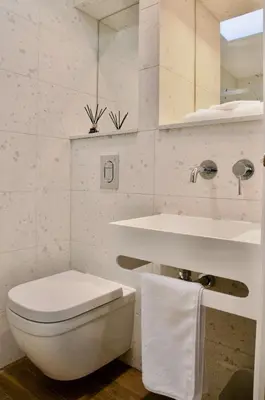 a white bathroom with a toilet and a sink at The Sunset Nook in Ipswich