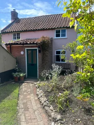 a small pink house with a green door at Rose Cottage Darsham - Suffolk Coastal in Darsham