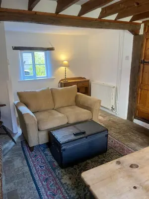 a living room with a couch and a suitcase at Rose Cottage Darsham - Suffolk Coastal in Darsham