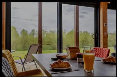 a table with food and a glass of orange juice at Meadow Valley Lodge 1 in Ipswich